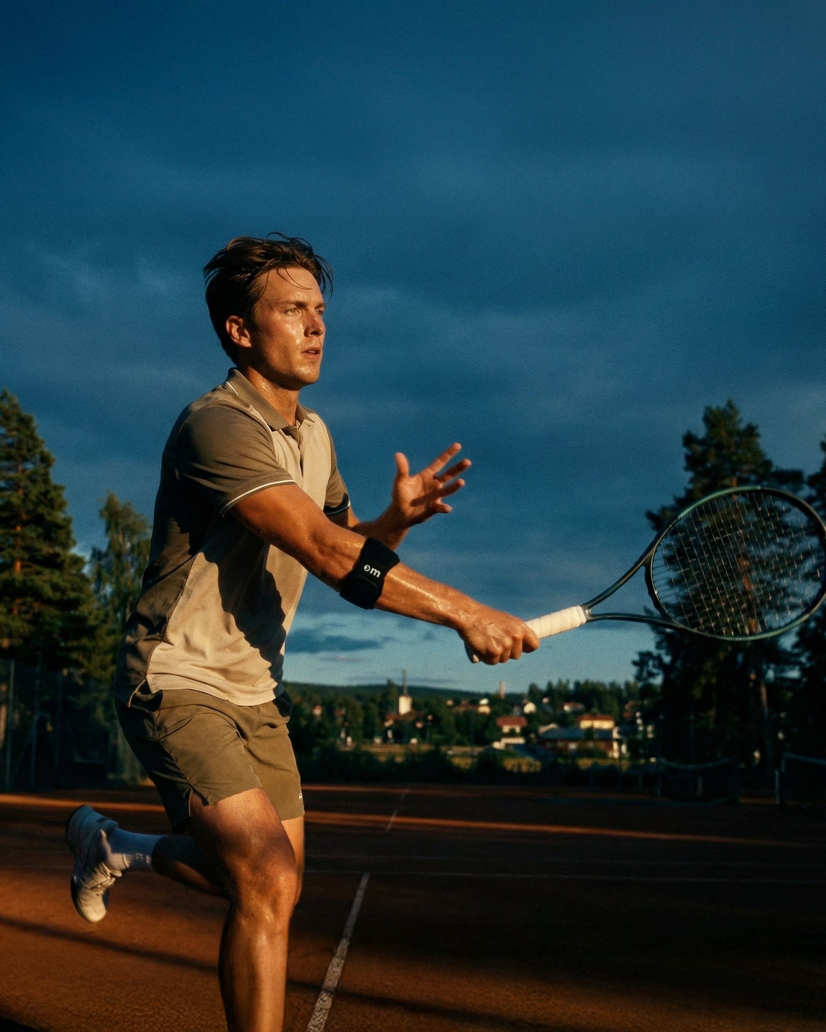 Man playing tennis on a court with a scenic background